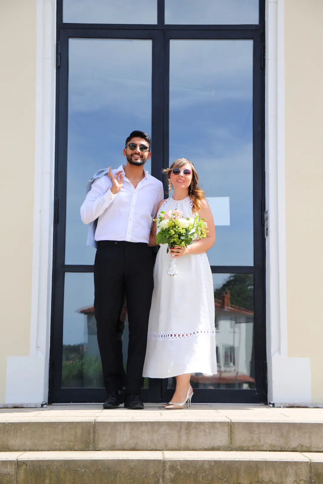 Chloé et Manan devant la porte vitrée de la mairie