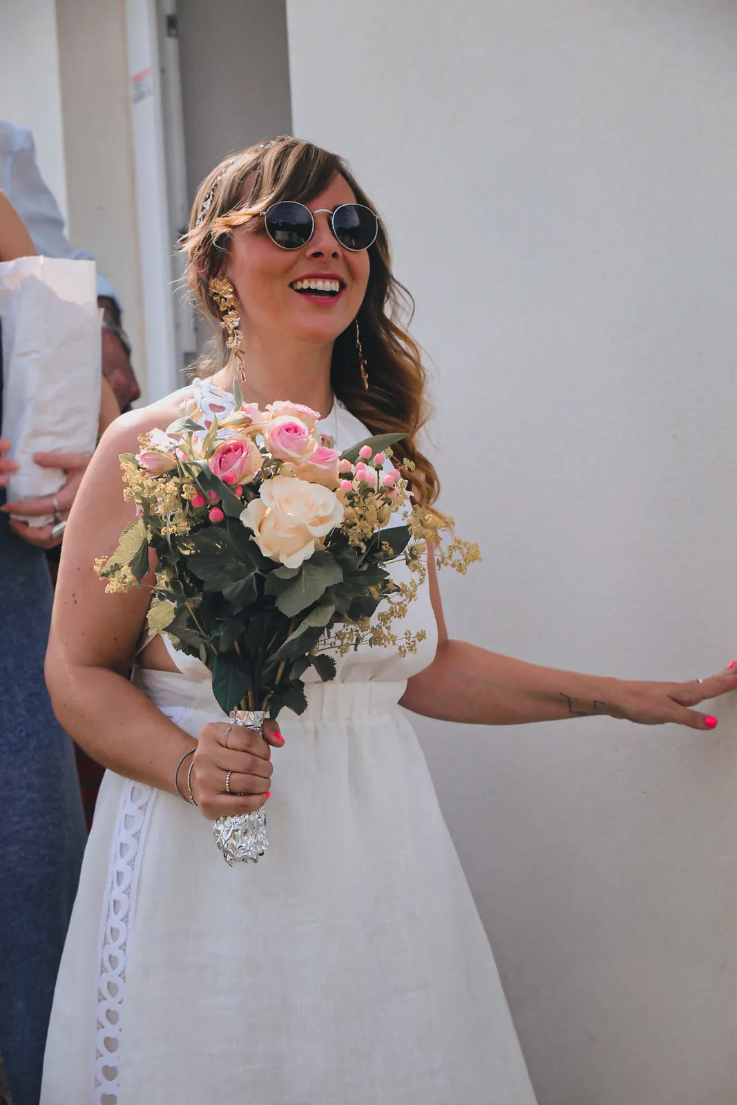 Chloé rit, son bouquet de roses à la main