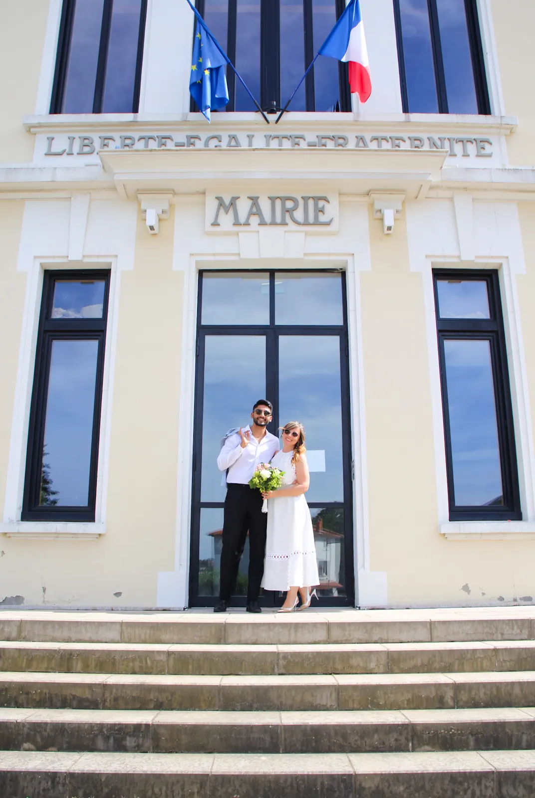 Les mariés sur les marches de la mairie, drapeaux tricolores