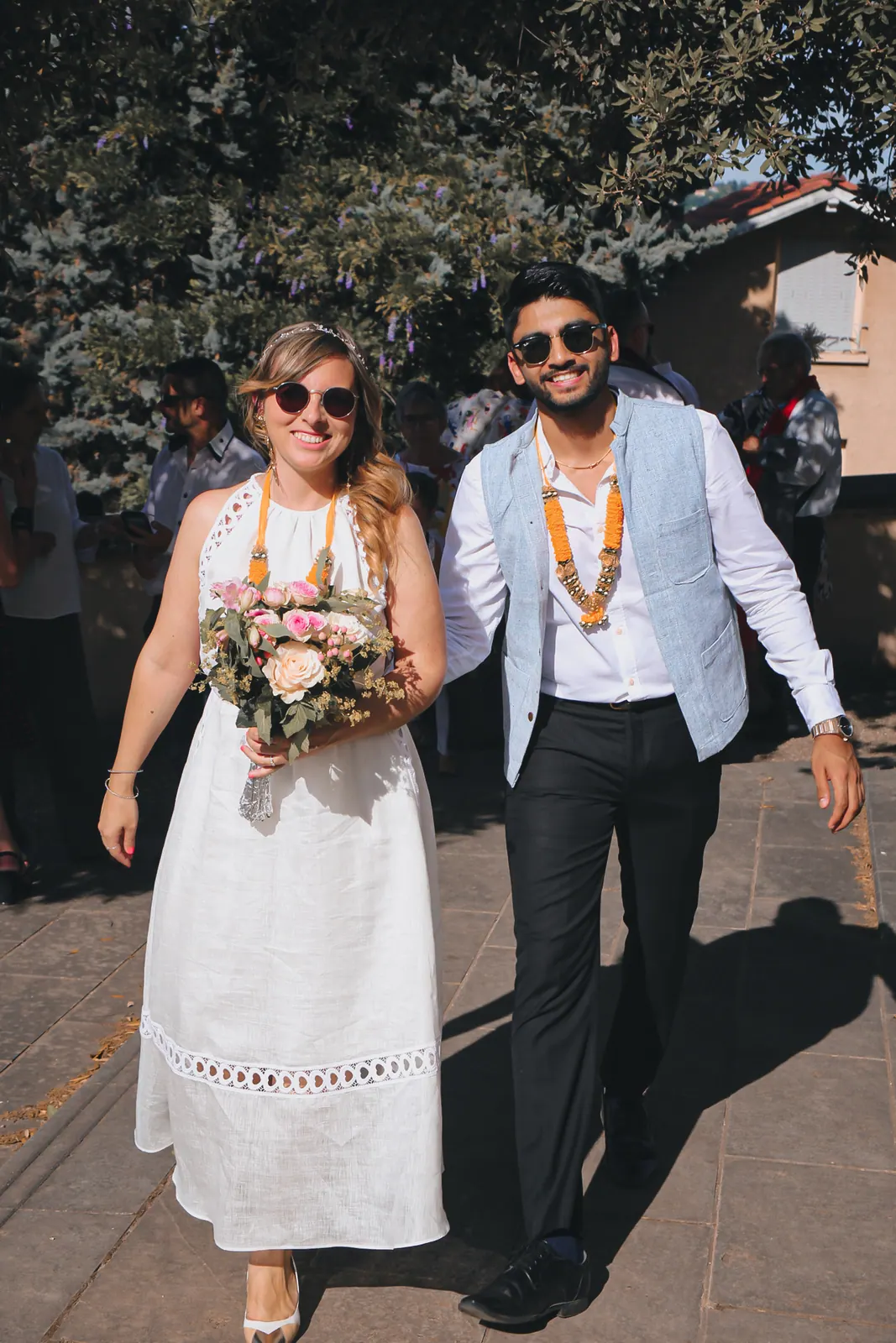 Les mariés sortent de la mairie, bouquet et colliers de fleurs
