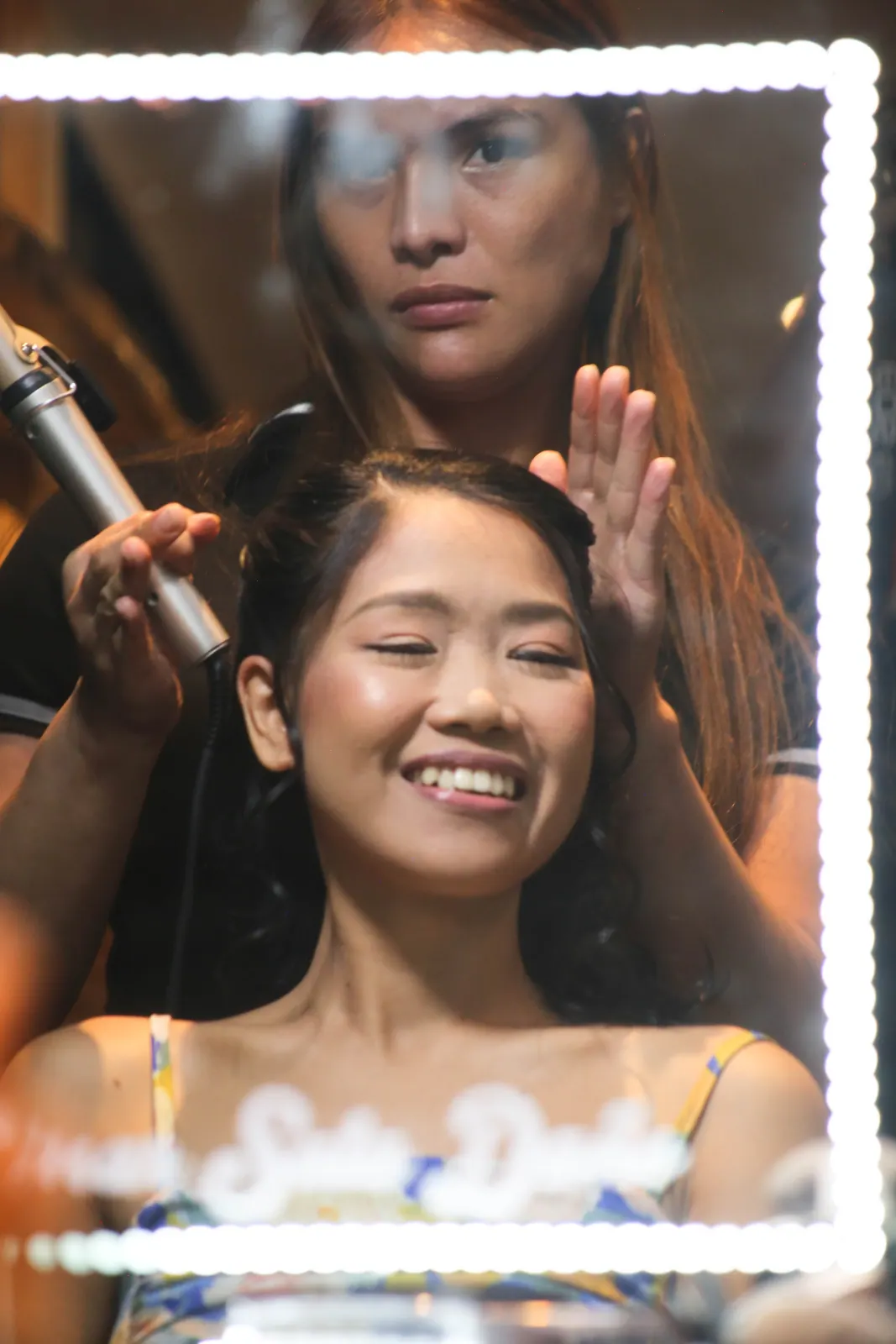 Julie Kristine rit pendant sa mise en beauté devant le miroir