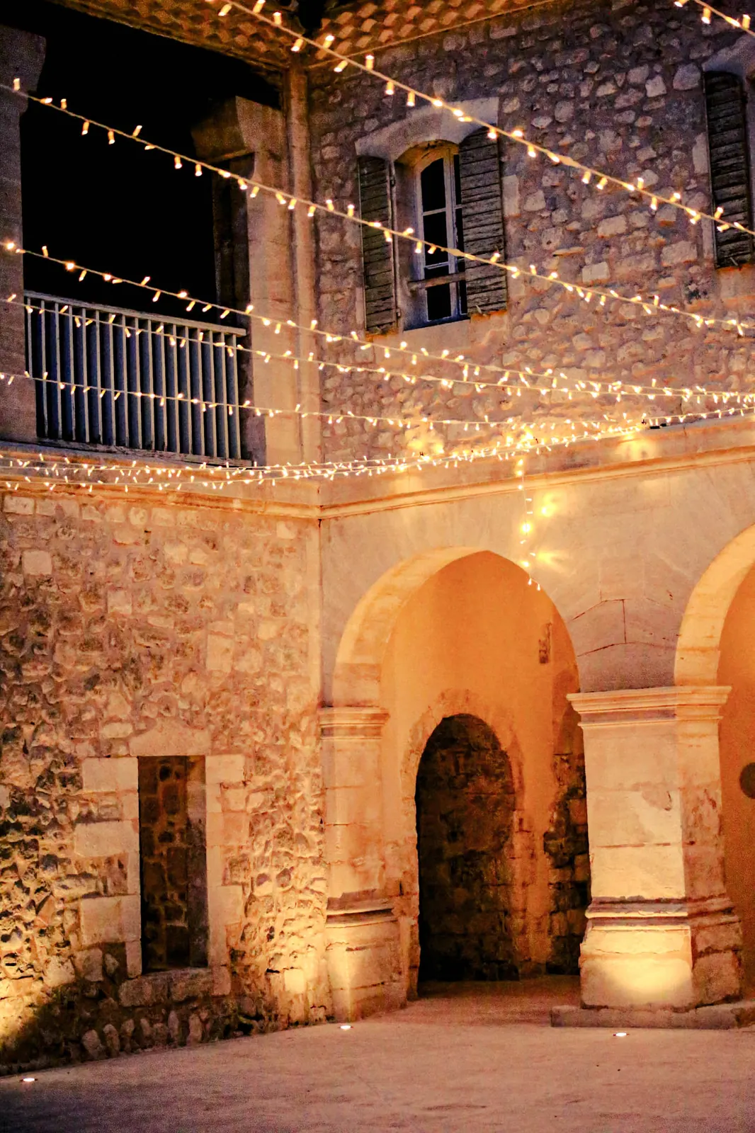 Cour du domaine en pierre illuminée de guirlandes