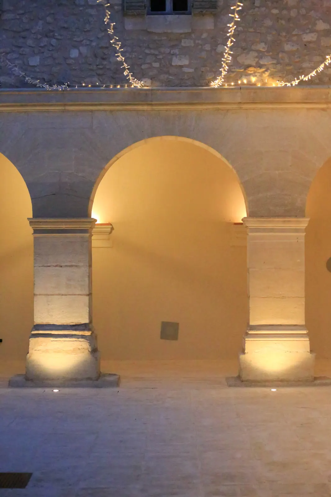 Arcades en pierre éclairées à la tombée de la nuit