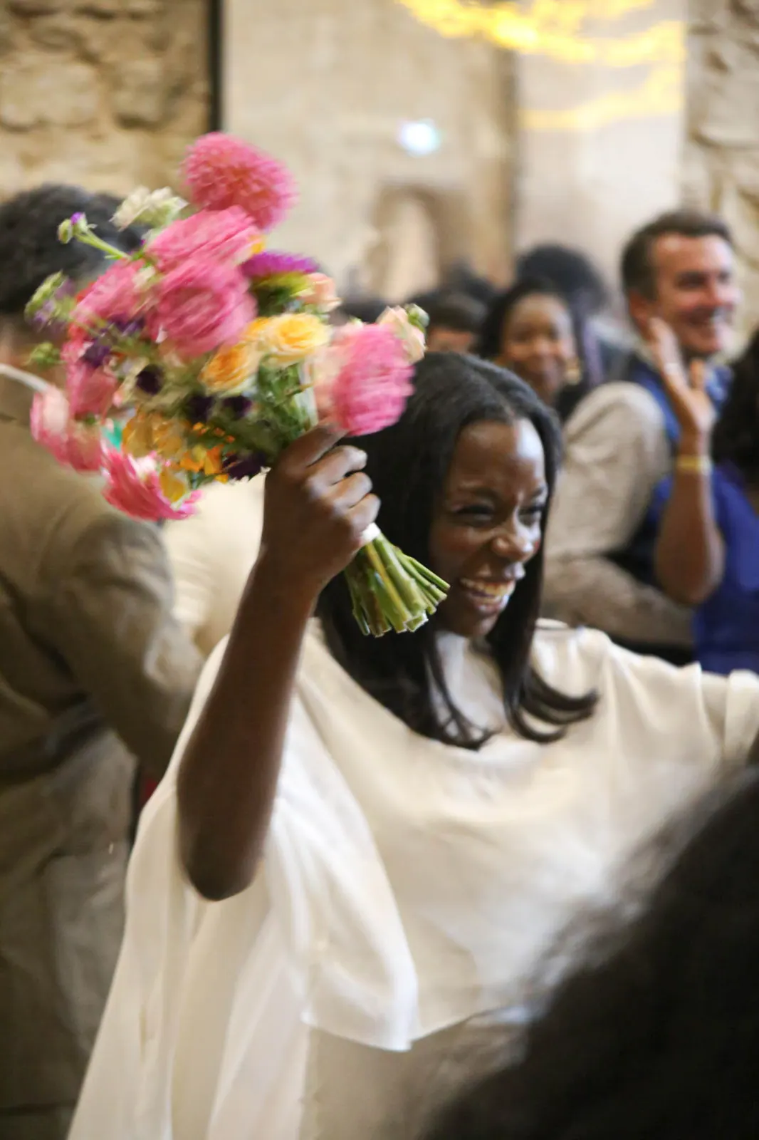 Tonya lève son bouquet de pivoines en souriant
